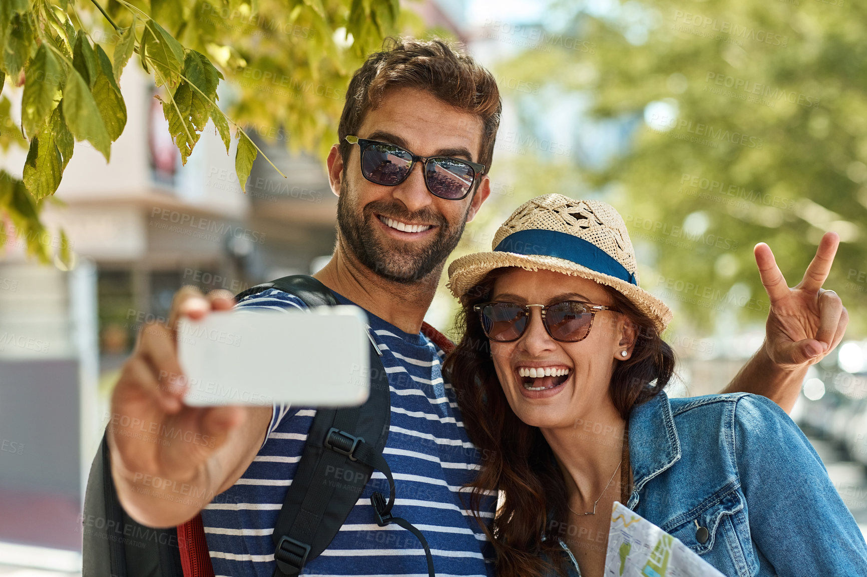 Buy stock photo Shot of a happy tourist couple posing for a selfie while exploring a foreign city together
