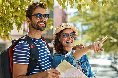 Buy stock photo Shot of a happy tourist couple using a map to explore a foreign city together