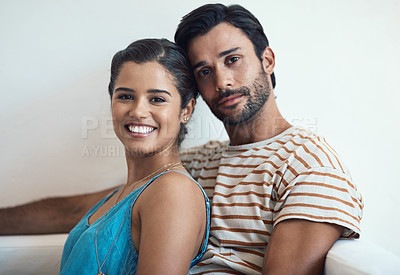 Buy stock photo Portrait of a happy young couple posing together on their couch at home