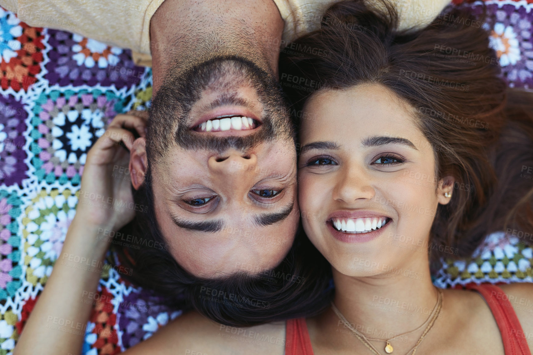 Buy stock photo Couple, portrait and happy on blanket, above or relax on ground for picnic, holiday and bonding. Indian people, man and woman in headshot for connection, love or care on sheet for vacation in Mumbai