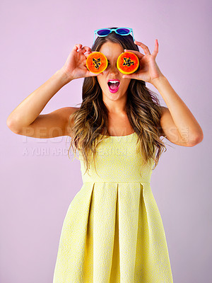 Buy stock photo Happy, papaya on eyes and woman in studio for healthy eating, nutrition and detox for wellness. Food, smile and person with fruit for organic diet, wellbeing and natural vitamins on pink background