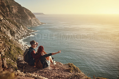 Buy stock photo High angle shot of an affectionate young couple taking in the view from a mountaintop