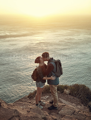 Buy stock photo Kiss, man and woman on mountain  for love, support and trekking for adventure or travel. Tourists, couple and landscape in nature or countryside for vacation together with sunrise for anniversary 