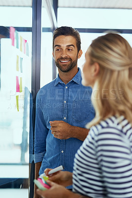 Buy stock photo Shot of two colleagues having a brainstorming session in a modern office