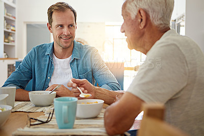 Buy stock photo Shot of a man having breakfast with his elderly father in the kitchen at home