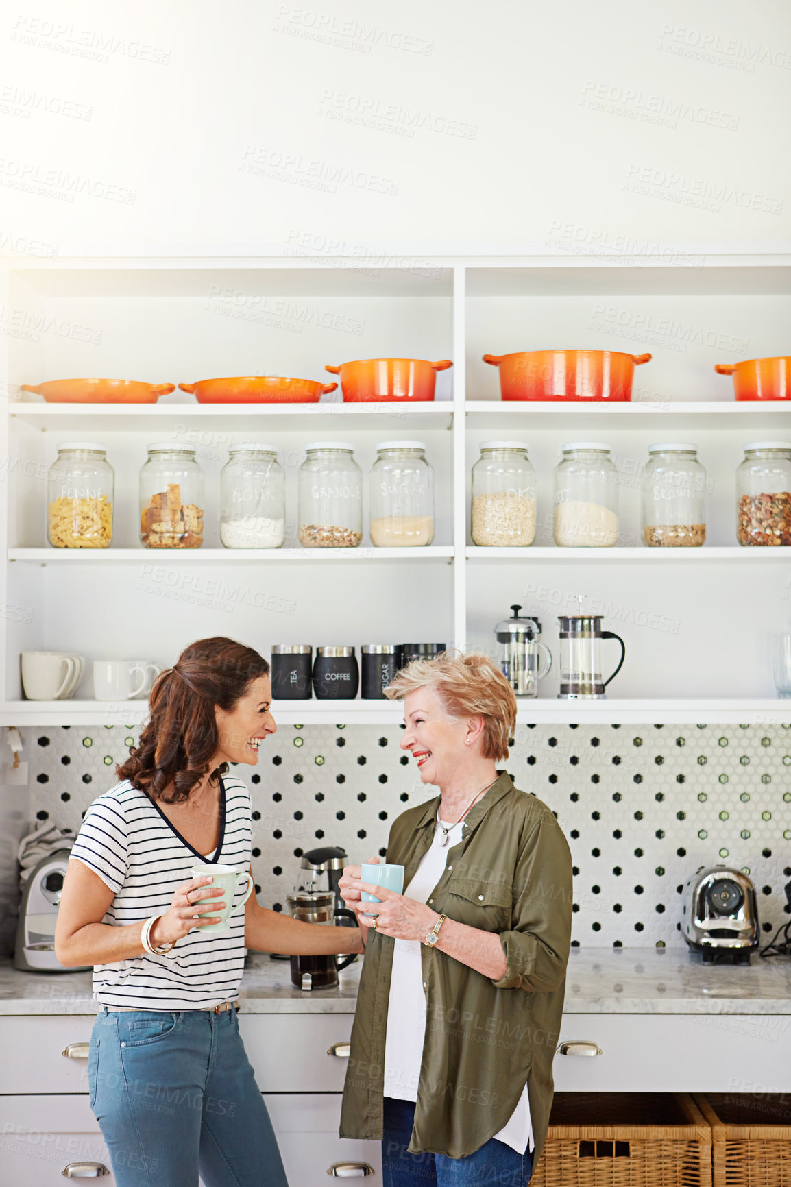 Buy stock photo Shot of a woman and her elderly mother catching up over coffee in the kitchen