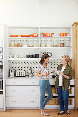 Buy stock photo Shot of a woman and her elderly mother catching up over coffee in the kitchen