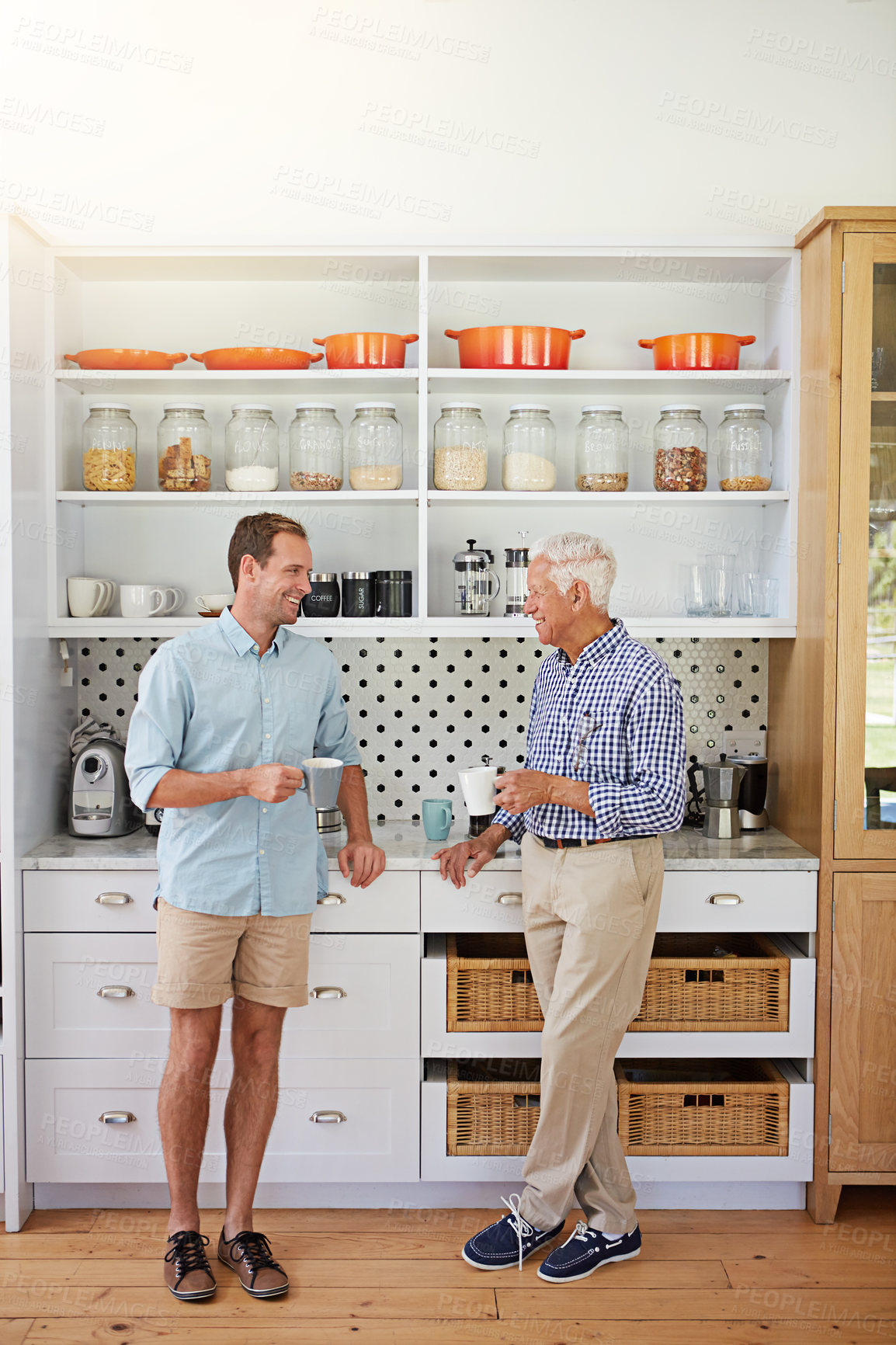 Buy stock photo Shot of a man and his elderly father catching up over coffee in the kitchen