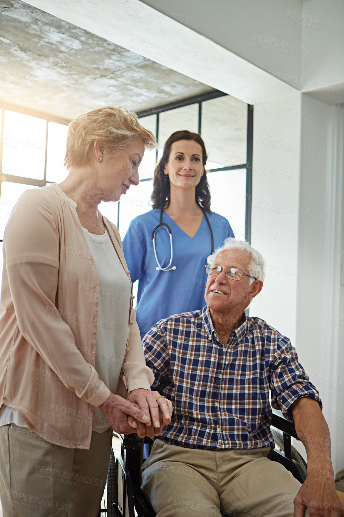 Buy stock photo Cropped shot of a nurse standing with a senior couple in their retirement home