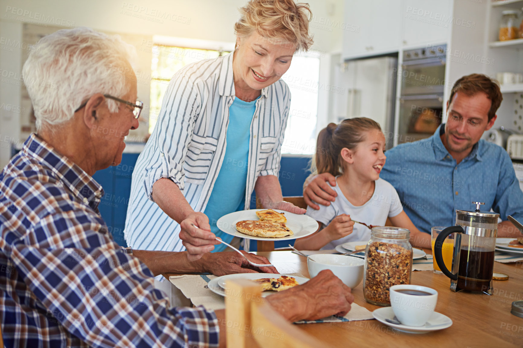 Buy stock photo Cropped shot of a multi generational family enjoying breakfast together at home