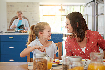 Buy stock photo Cropped shot of a little girl enjoying breakfast with her mother