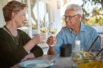 Buy stock photo Shot of a happy senior couple toasting with wine during a leisurely lunch outdoors