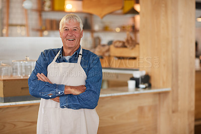 Buy stock photo Portrait of a confident senior business owner posing with an apron on in his coffee shop