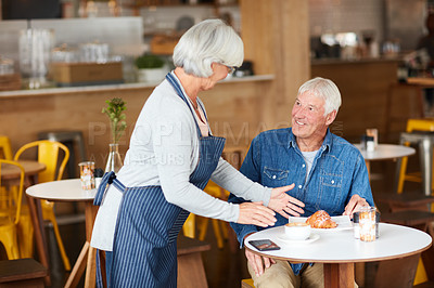 Buy stock photo Shot of a happy senior business owner serving a customer in her coffee shop