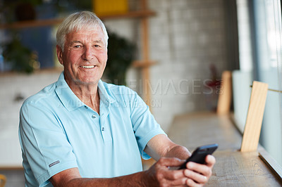 Buy stock photo Cropped portrait of a senior man using his cellphone while sitting in a coffee shop