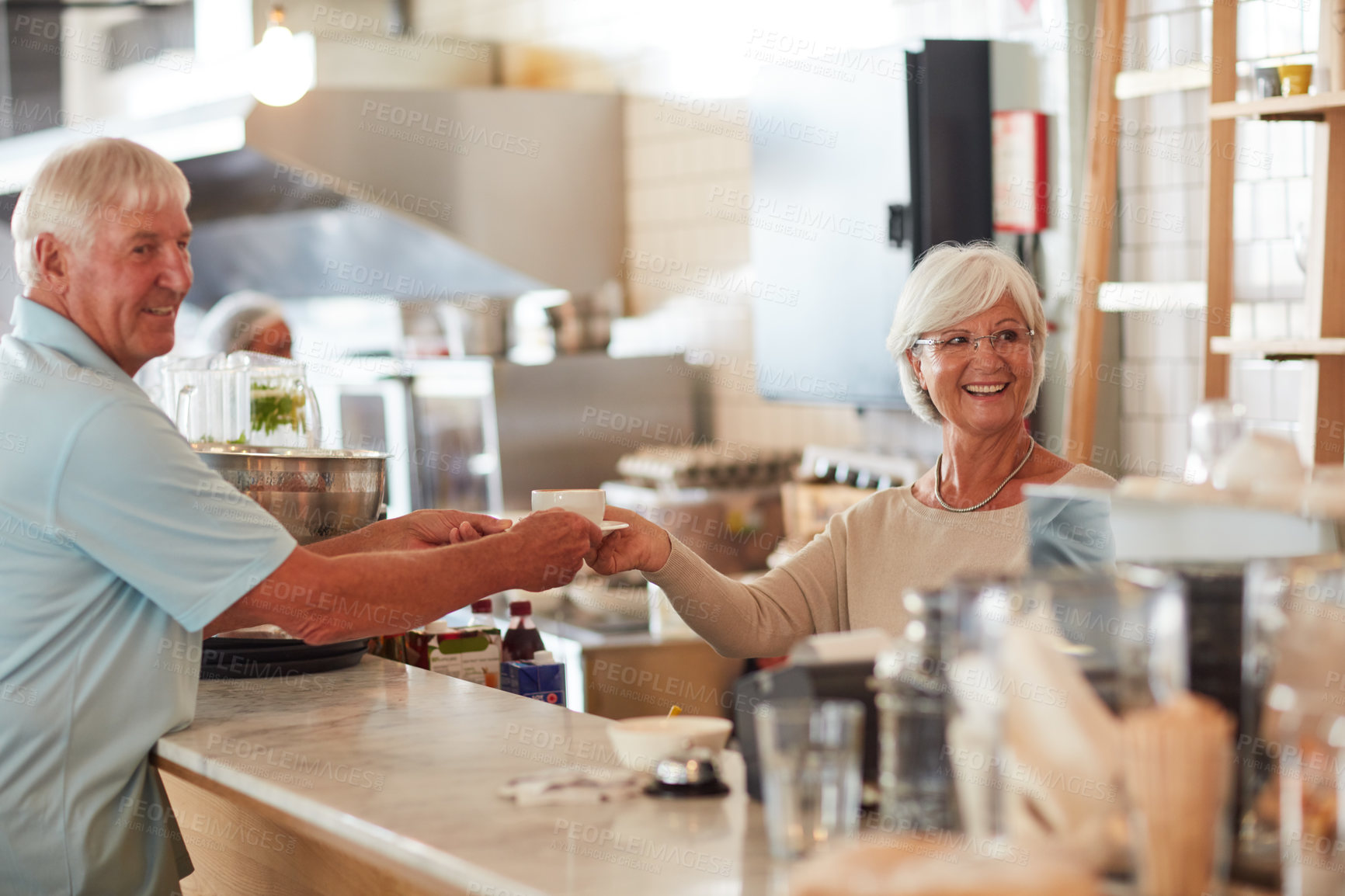Buy stock photo Shot of a happy senior woman serving a customer a cup of coffee in a cafe