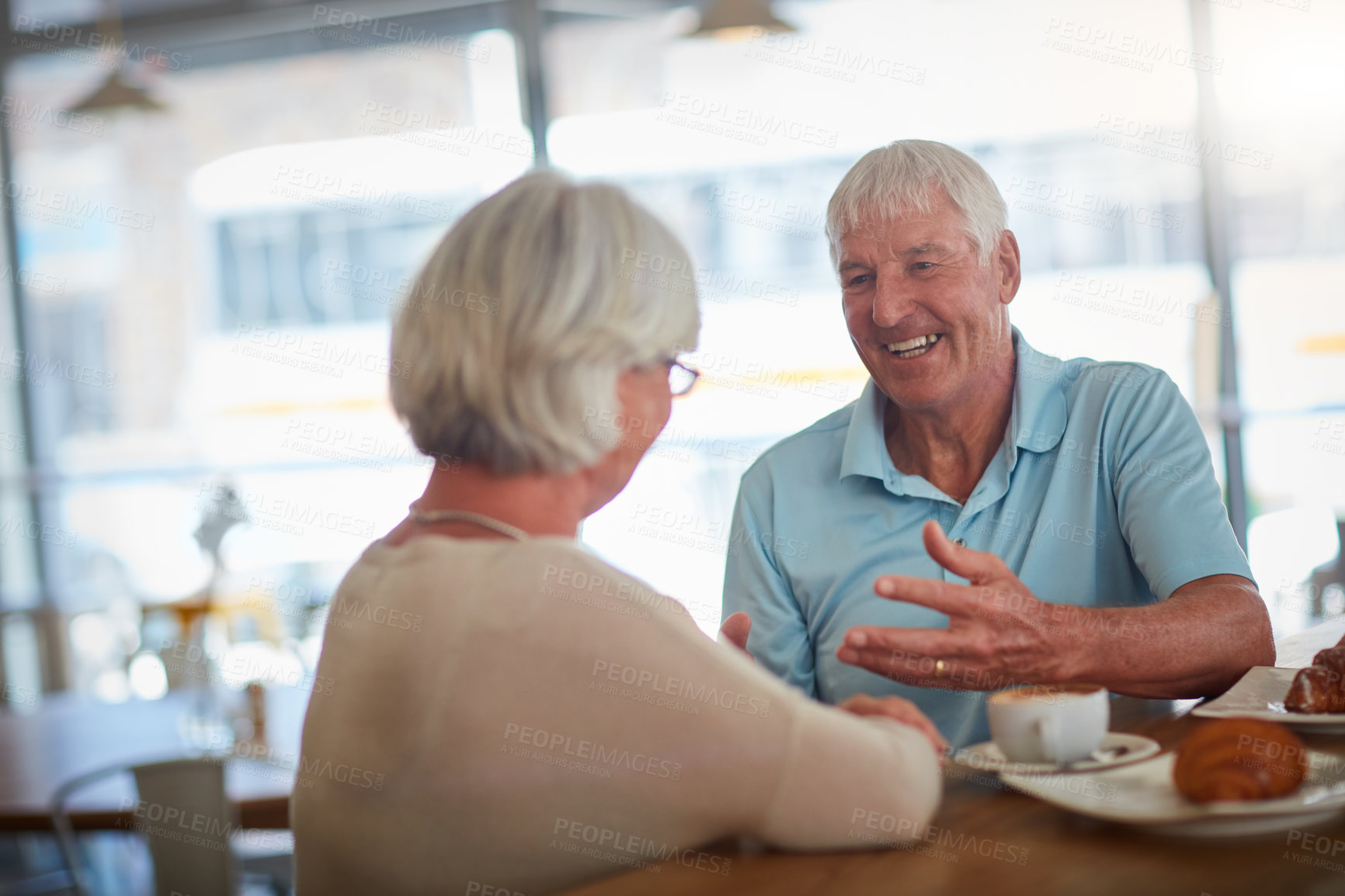 Buy stock photo Cropped shot of an affectionate senior couple in their local coffee shop