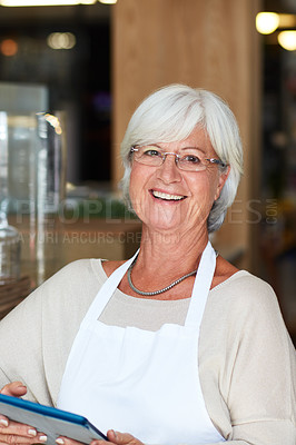 Buy stock photo Portrait of a happy senior woman using a digital tablet to manage her small business