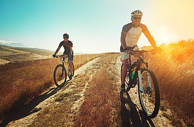 Buy stock photo Shot of two cyclists out cycling in the countryside