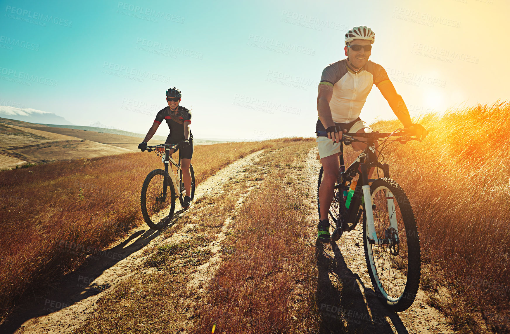 Buy stock photo Shot of two cyclists out cycling in the countryside