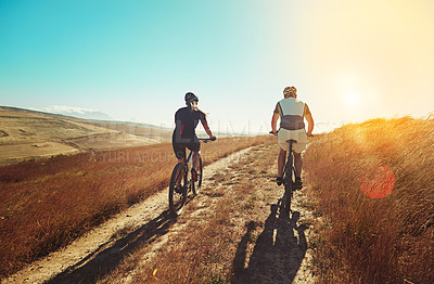 Buy stock photo Shot of two cyclists out cycling in the countryside