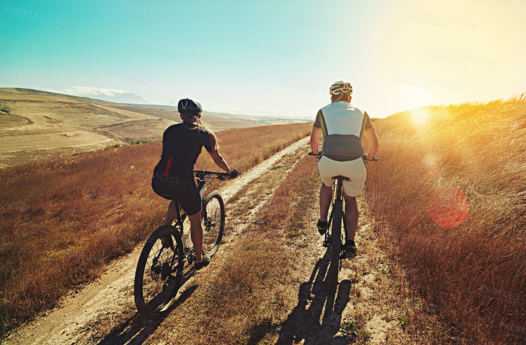 Buy stock photo Shot of two cyclists out cycling in the countryside