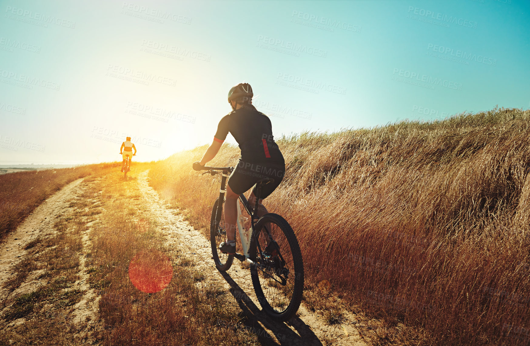 Buy stock photo Shot of two cyclists out cycling in the countryside