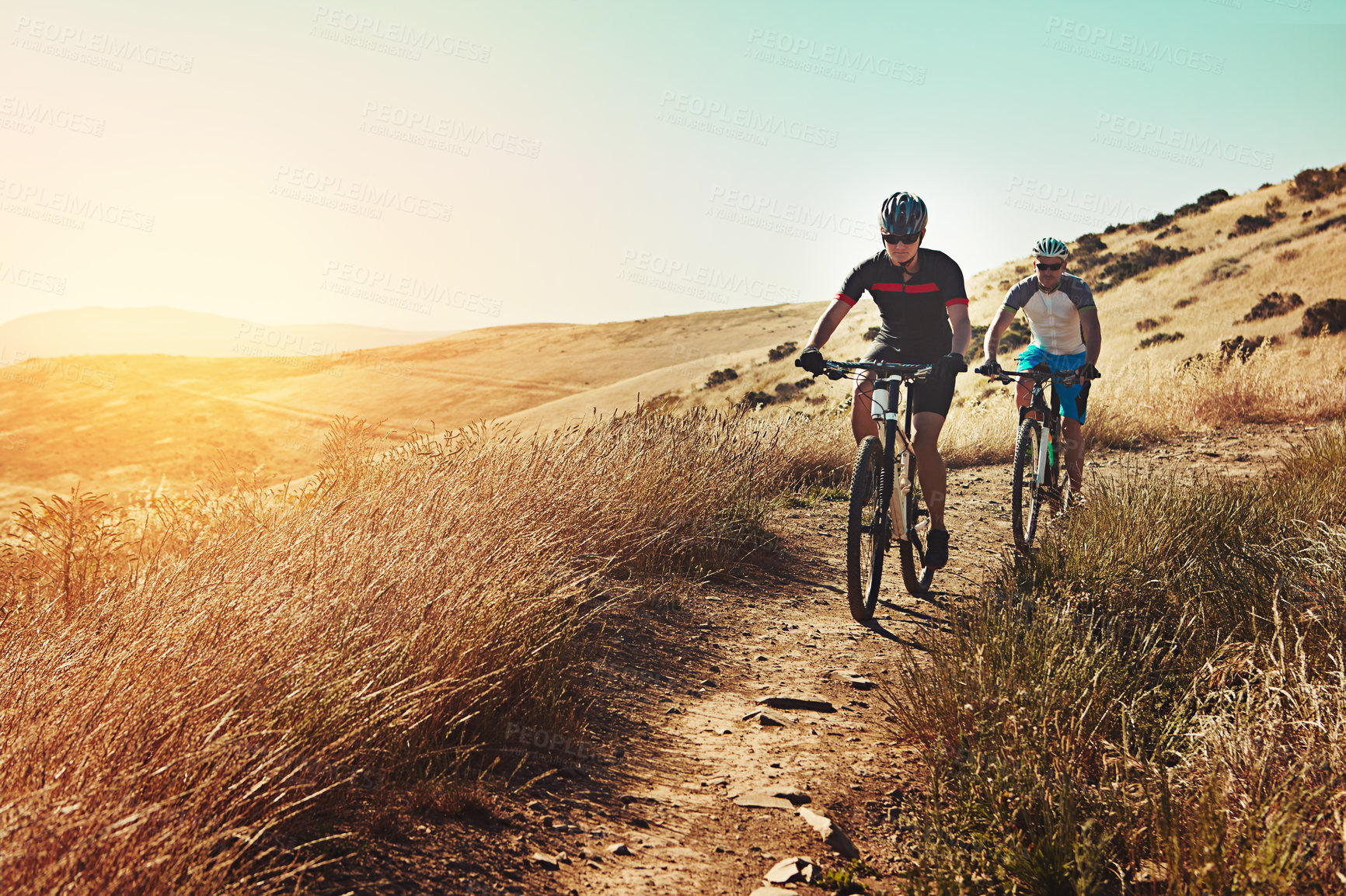 Buy stock photo Shot of two cyclists out cycling in the countryside