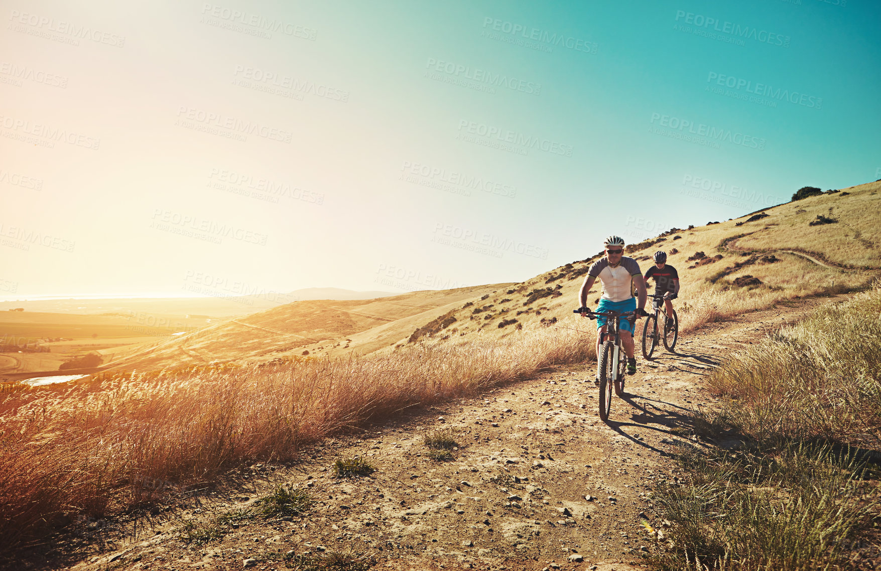 Buy stock photo Shot of two cyclists out cycling in the countryside