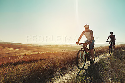 Buy stock photo Shot of two cyclists out cycling in the countryside