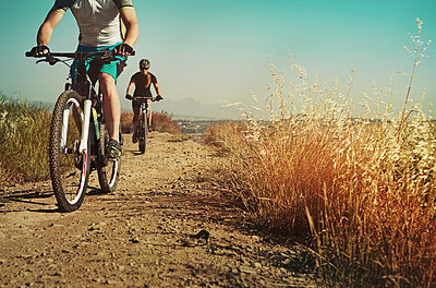 Buy stock photo Shot of two cyclists out cycling in the countryside