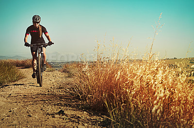 Buy stock photo Cropped shot of  an adventurous woman out cycling in the countryside