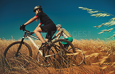 Buy stock photo Shot of two cyclists out cycling in the countryside