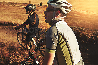 Buy stock photo Shot of two cyclists out cycling in the countryside