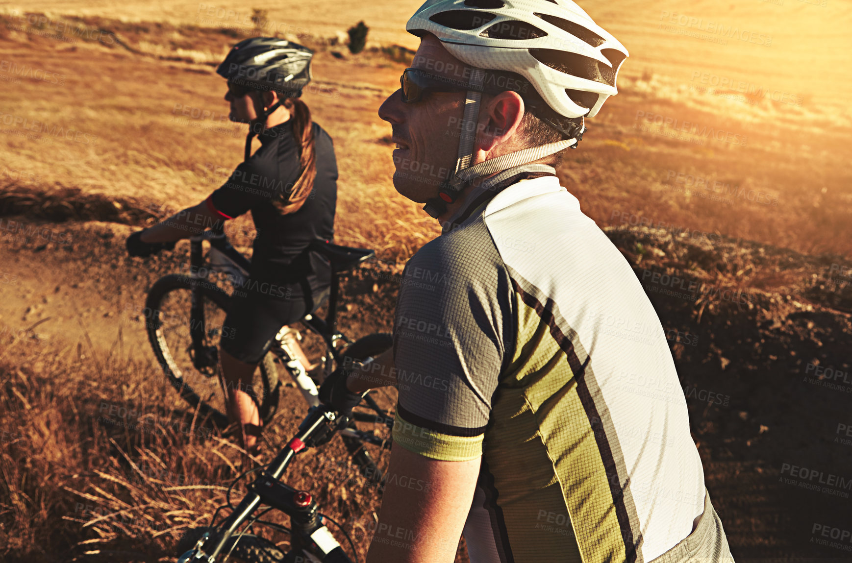 Buy stock photo Shot of two cyclists out cycling in the countryside