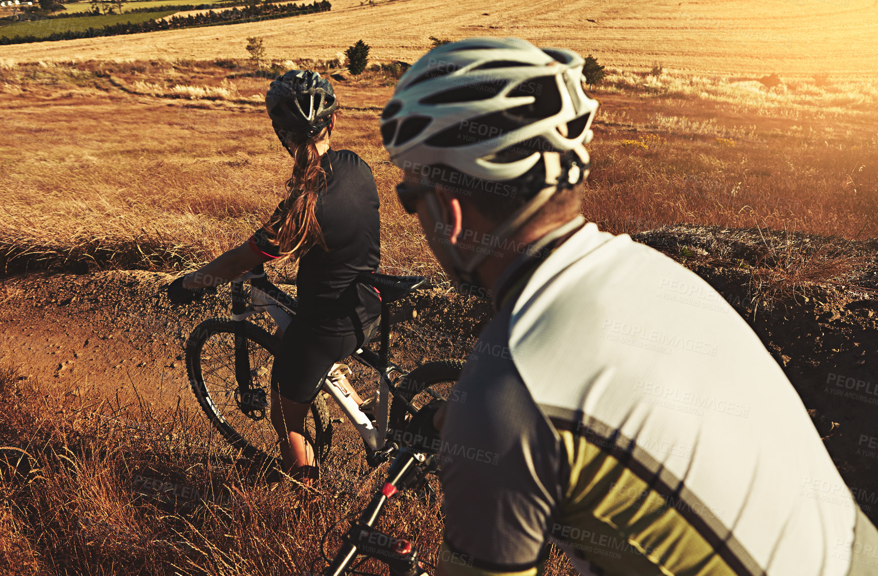 Buy stock photo Shot of two cyclists out cycling in the countryside