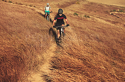 Buy stock photo Shot of two cyclists out cycling in the countryside