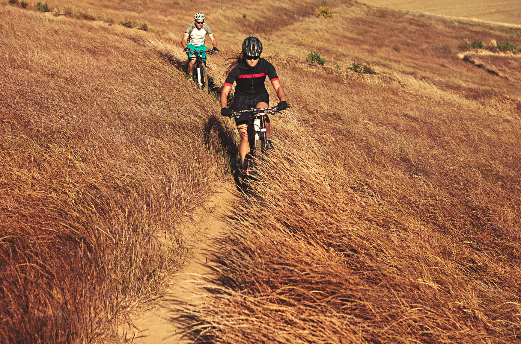 Buy stock photo Shot of two cyclists out cycling in the countryside