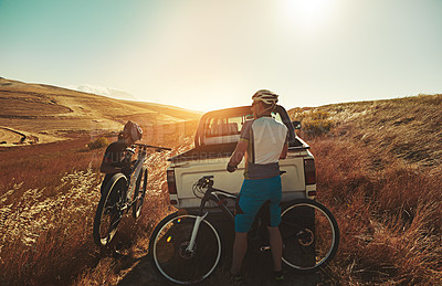 Buy stock photo Shot of a pair of adventurous mountain bikers getting ready to explore a new trail together