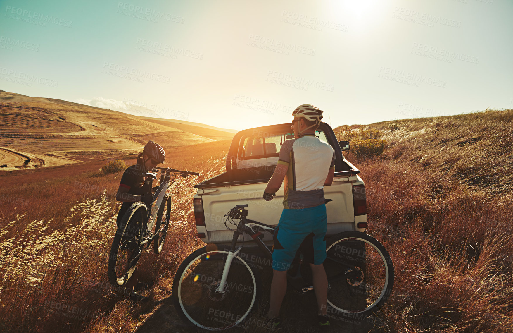 Buy stock photo Shot of a pair of adventurous mountain bikers getting ready to explore a new trail together