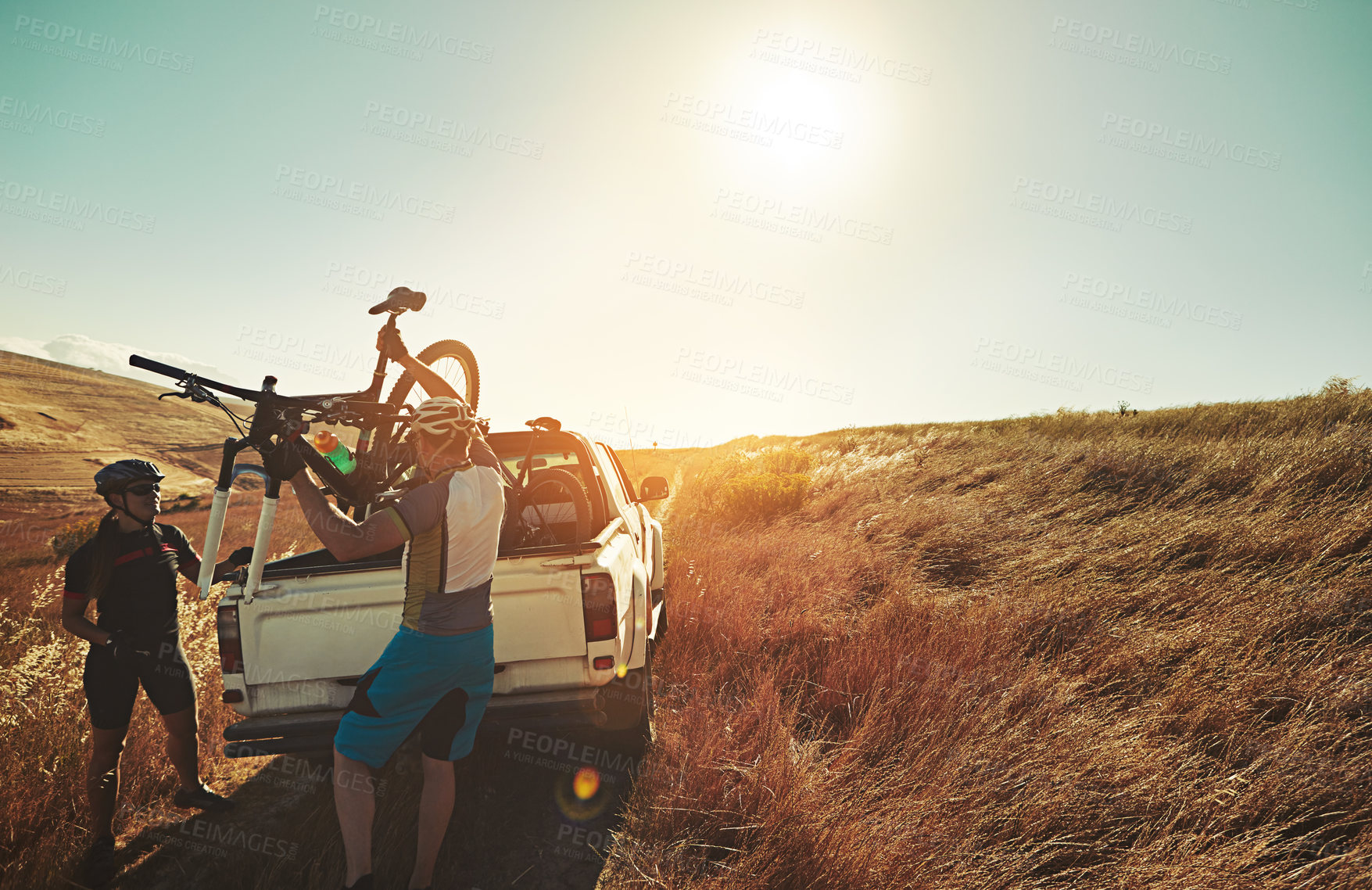 Buy stock photo Shot of a pair of adventurous mountain bikers getting ready to explore a new trail together