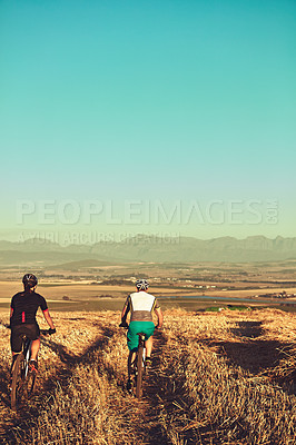 Buy stock photo Shot of two cyclists out cycling in the countryside