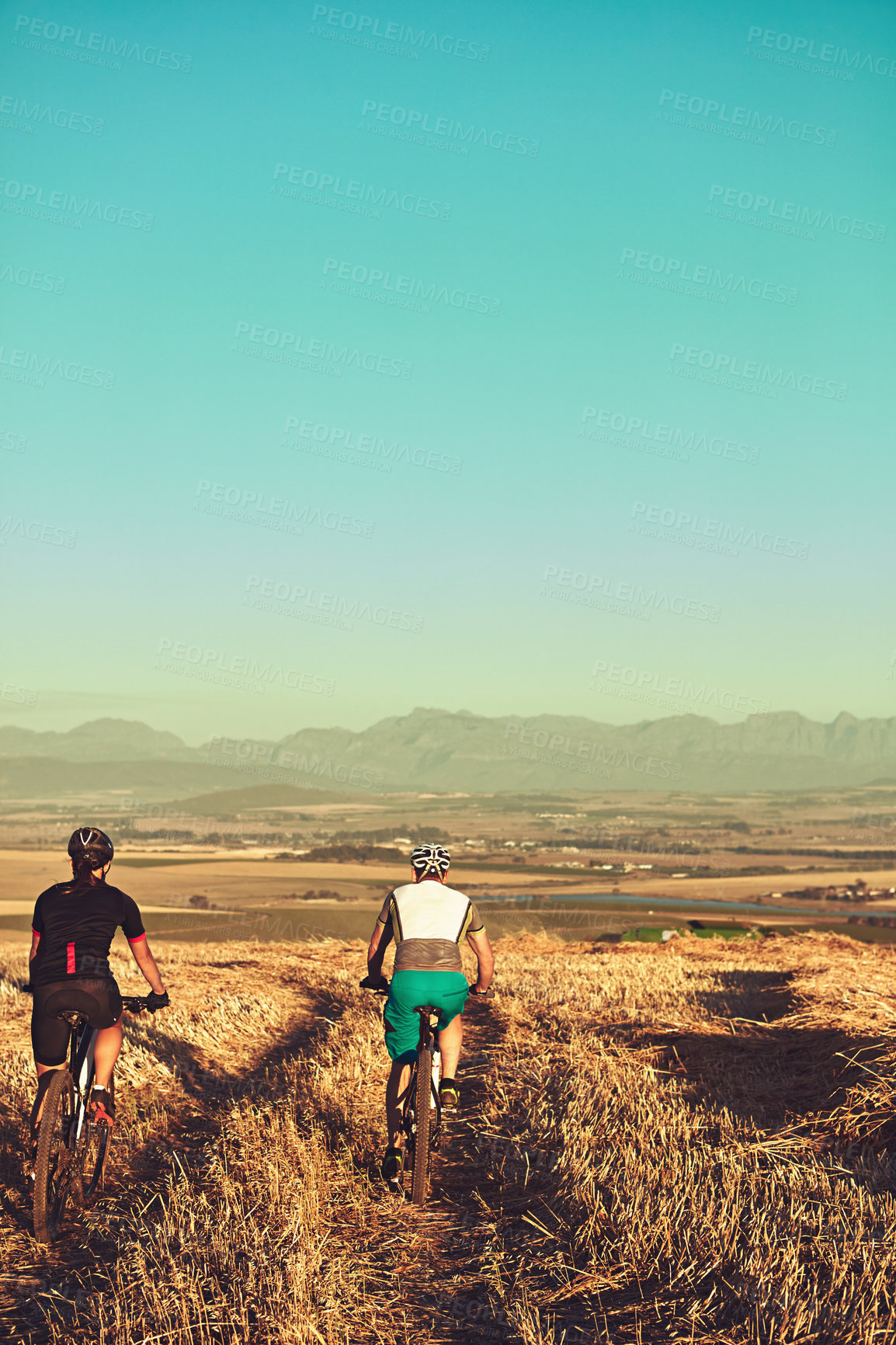 Buy stock photo Shot of two cyclists out cycling in the countryside