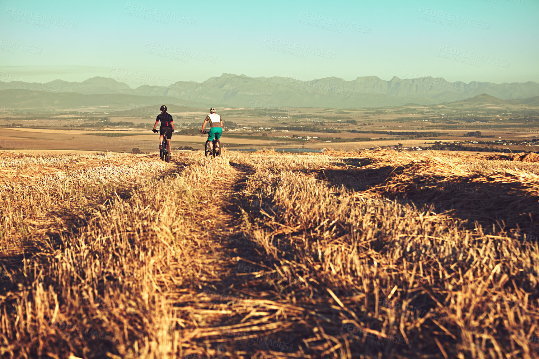 Buy stock photo Shot of two cyclists out cycling in the countryside