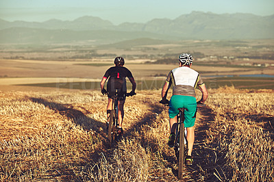 Buy stock photo Shot of two cyclists out cycling in the countryside