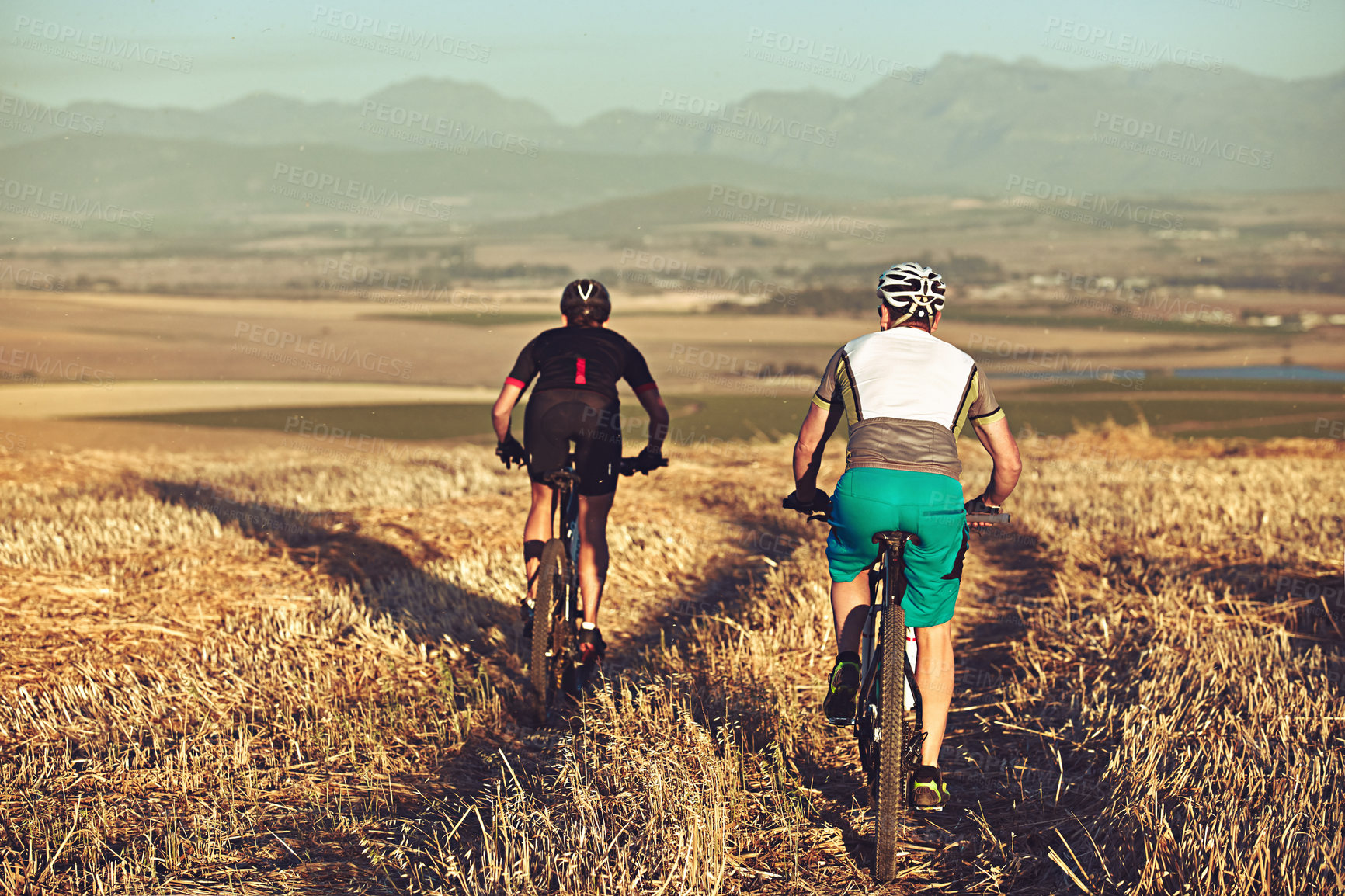 Buy stock photo Shot of two cyclists out cycling in the countryside