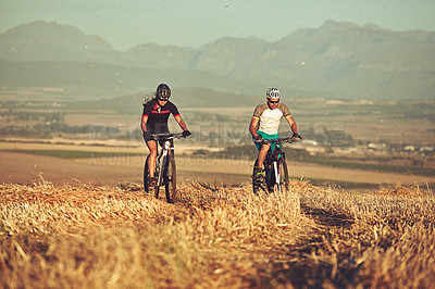 Buy stock photo Shot of two cyclists out cycling in the countryside