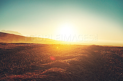 Buy stock photo Shot of the sun setting over a beautiful rural landscape