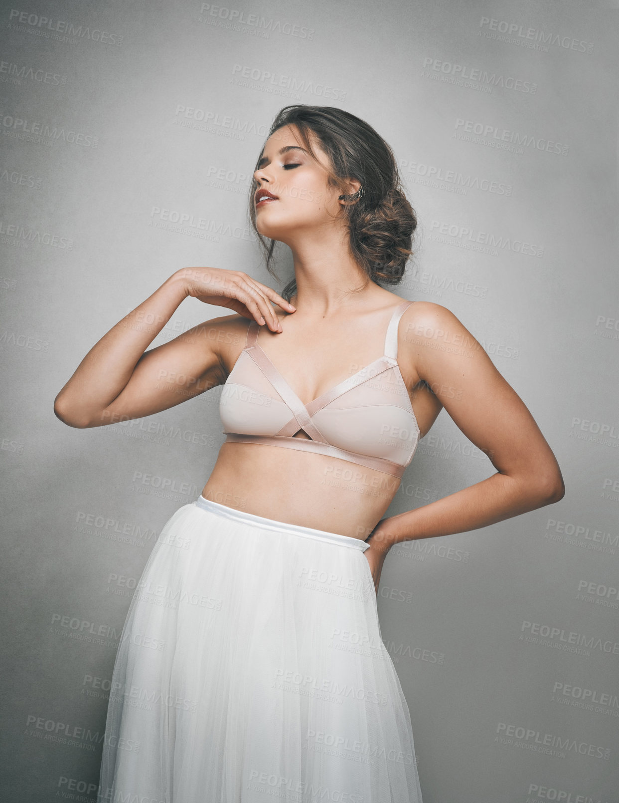 Buy stock photo Shot of a beautiful young woman posing in studio while wearing a bra and ballet skirt