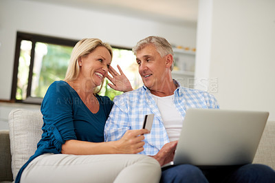 Buy stock photo Cropped shot of a mature couple making a credit card payment on a laptop at home